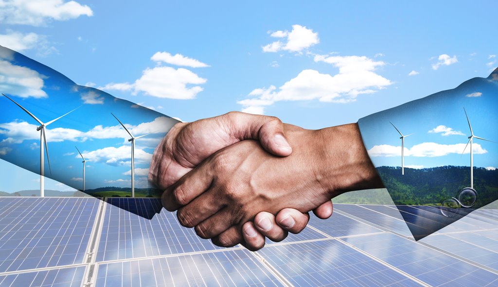 Picture of a handshake with solar panels in the background