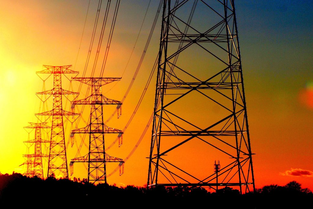 Transmission towers with an orange-sky backdrop