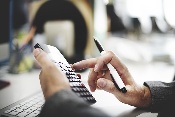 shot of a person's hands operating a calculator